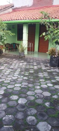 a house with a stone ground in front of a building at Omah 365 Homestay in Sentool