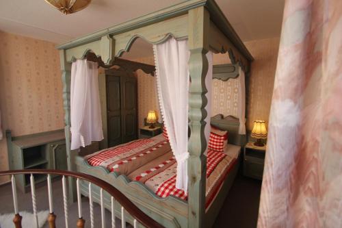a bedroom with a canopy bed and a staircase at Hotel SchwarzaBurg in Schwarzburg