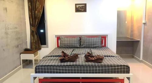 a bedroom with a bed with shoes on it at Kidthuengpark in Si Racha