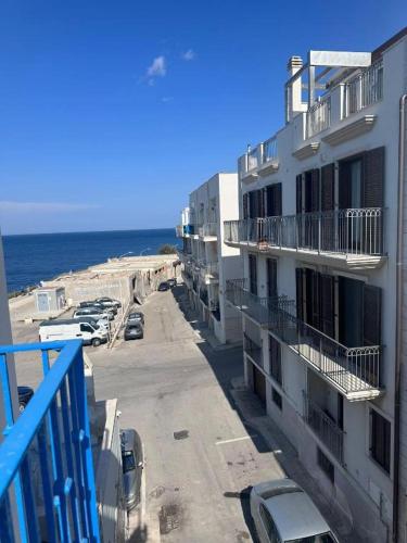 a view of the beach from a balcony of a building at Cielo | Suite con Bagno e Cucina Condivisa – Centrale in Polignano a Mare