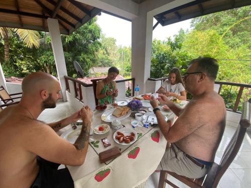 a group of people sitting at a table eating food at GB Royal Stay Nuwara Wewa in Nikawatawana
