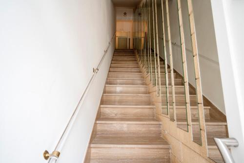 a long staircase in a building with wooden floors at Cielo | Suite con Bagno e Cucina Condivisa – Centrale in Polignano a Mare