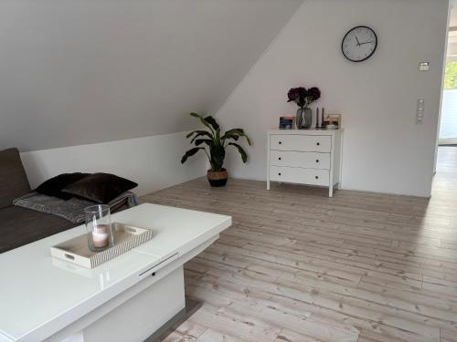 a white living room with a couch and a table at Haus Anna O in Westoverledingen