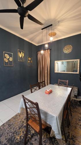 a dining room with a table and a ceiling fan at Deena Homestay - 4BR with 4 Airconds in Jerantut
