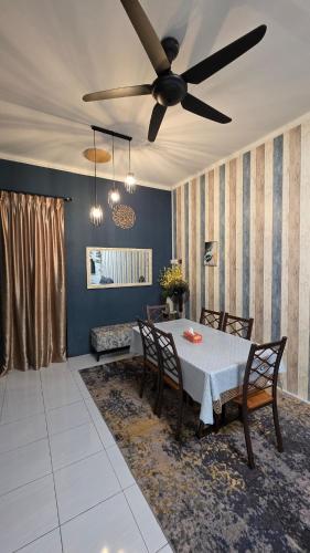 a dining room with a table and a ceiling fan at Deena Homestay - 4BR with 4 Airconds in Jerantut
