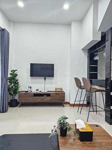 a living room with a flat screen tv on a wall at Hatyai Luxe Stay 2BR Private House up to 8 Guests near Hat Yai Park in Hat Yai