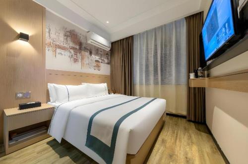 una camera d'albergo con un letto e una TV a schermo piatto di City Comfort Inn Wuhan Jindi Plaza Luojiagang Metro Station a Wuhan