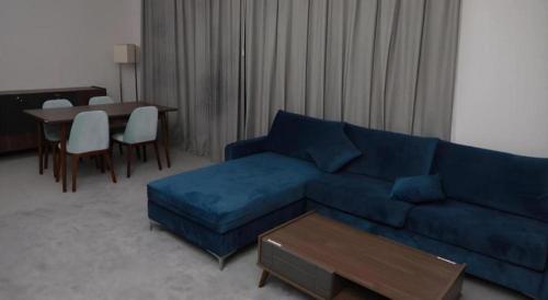 a living room with a blue couch and a table at ALAZMI HOTEL in Dubai