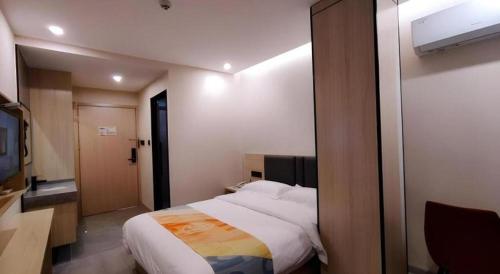 a bedroom with a large bed and a window at Shell Hotel Wuxi Huishan District Chang'an Town in Wuxi