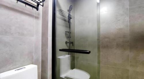 a bathroom with a toilet and a glass shower at Shell Hotel Wuxi Huishan District Chang'an Town in Wuxi