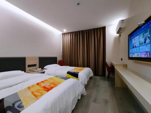 a hotel room with two beds and a flat screen tv at Shell Hotel Wuxi Huishan District Chang'an Town in Wuxi
