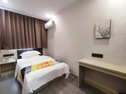 a hotel room with a bed and a window at Shell Hotel Wuxi Huishan District Chang'an Town in Wuxi