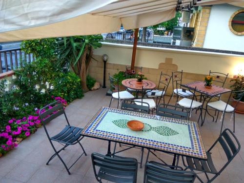 an outdoor patio with tables and chairs and flowers at Le Camelie in Ginosa Marina