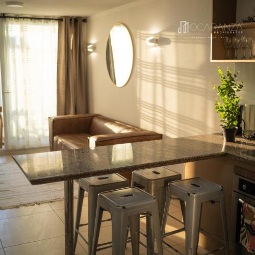 a kitchen with a counter and stools in a room at Hermoso Depto sector Enjoy in Coquimbo