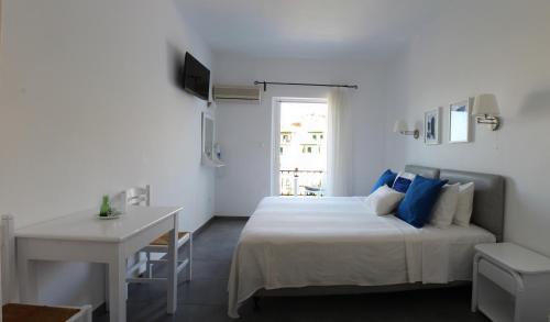 1 dormitorio con cama, mesa y escritorio en Villa Nefeli, en Batsi