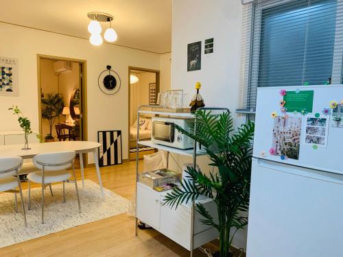 a kitchen and dining room with a refrigerator and a table at Cozy Erin Stay, Itaewon Seoul in Seoul