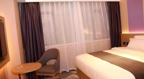 a hotel room with a bed and a chair and a table at Lavande Hotel Shenzhen East Gate Wanxiang City Guomao Metro Statipn in Shenzhen