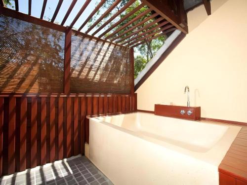 baño con bañera grande y ventana en Baan Talay Dao Resort, en Hua Hin