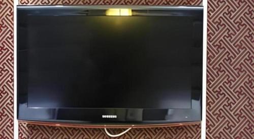 a flat screen tv sitting on top of a wall at Milu Hotel in Guangzhou