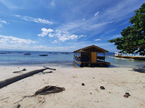 a boat on the shore of a beach at Stanley House Seaview Apartments in Panglao