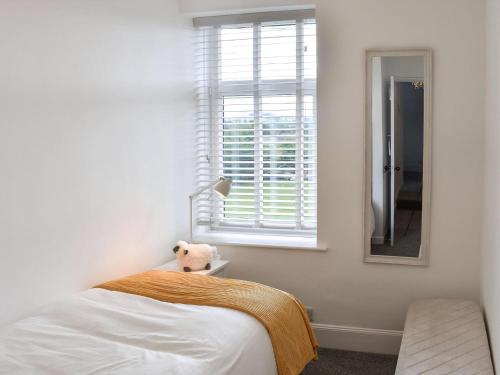 a bedroom with a bed and a window and a teddy bear at The Croft in Stanhope