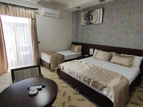 AşağıyanlarにあるKoç Otel Çankırıのベッド2台とテーブルがあるホテルの部屋