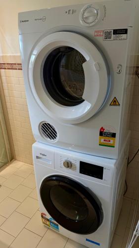 a washer and dryer stacked on top of each other at 2 Bdrm Walkerville Apartment - Spacious, ducted heating & cooling, centerally located! in North Adelaide