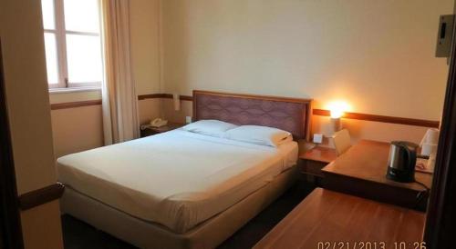 a hotel room with a bed and a window at Four Chain View Hotel in Singapore