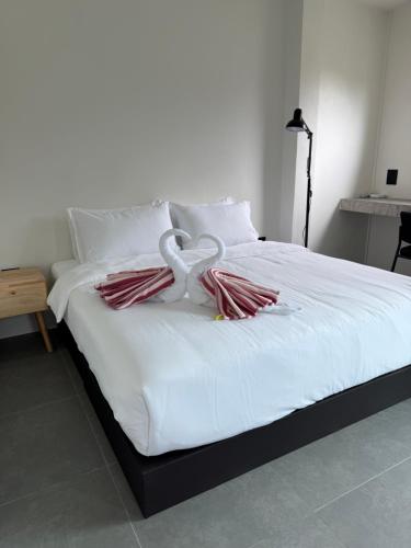 a white bed with white pillows and a heart on it at JJ and J Garden1 Pai in Pai