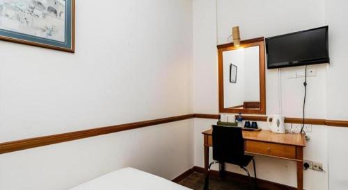 a hotel room with a desk and a mirror at Four Chain View Hotel in Singapore