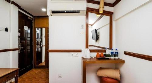 a room with a kitchen with a refrigerator and a tv at Four Chain View Hotel in Singapore
