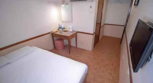 a small room with a bed and a television at Four Chain View Hotel in Singapore