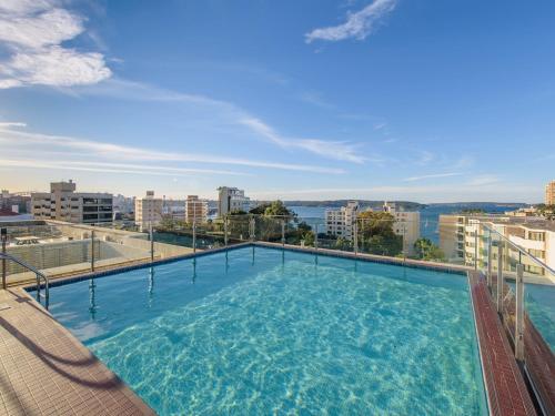a large swimming pool on top of a building at Harbour View Apt with Rooftop Pool in Sydney