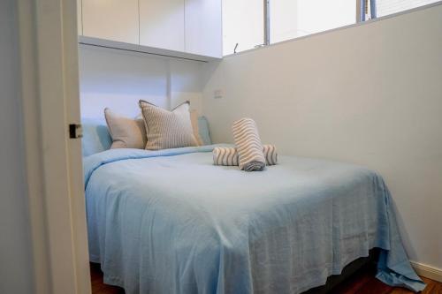 a bed with two stuffed animals on top of it at Harbour View Apt with Rooftop Pool in Sydney