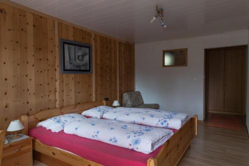 a bedroom with a bed and a chair in it at B & B Apartments Ortlerblick in Sluderno