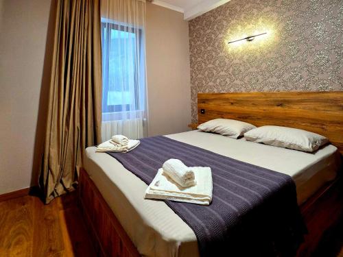 a bedroom with a large bed with towels on it at Guest house "Soulmate" in Ambrolauri
