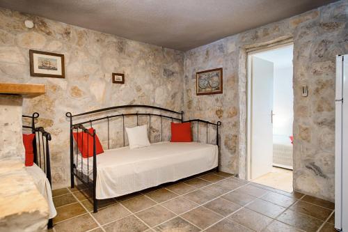 a bedroom with a bed in a room with stone walls at Apartments Perla in Rukavac