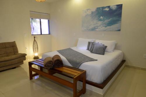 - une chambre avec un grand lit et un canapé dans l'établissement Oasis Tajaja Pousada, à Jacumã