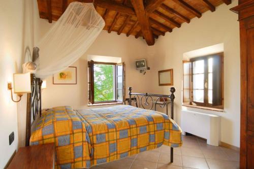 a bedroom with a bed and a table and a window at Tenuta Il Tresto in Poggibonsi