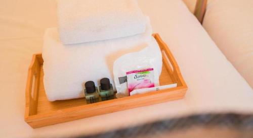 a wooden tray with someones items on a bed at Bangsaen Villa Hotel in Si Racha