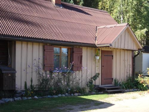 a small white house with a red roof at Vējavas in Svettsiyems