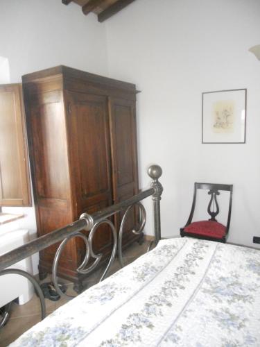 a bedroom with a bed and a wooden cabinet at Tenuta Il Tresto in Poggibonsi