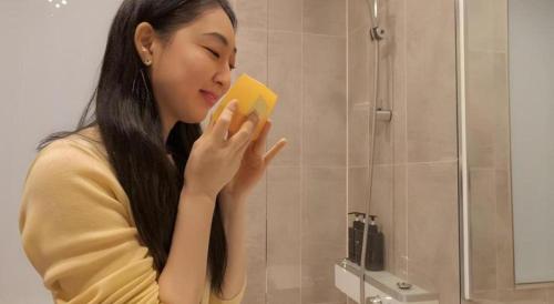 a woman holding a book in front of a mirror at CS Premier Hotel in Seoul