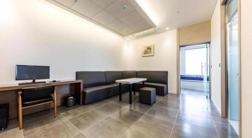 a room with a couch and a table and a desk at CS Premier Hotel in Seoul