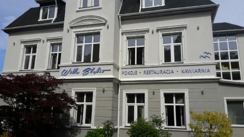 a white building with blue writing on it at Willa Błękit Hotel by Dorota Szelągowska in Mielno