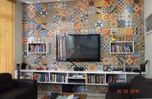 a living room with a tv on a wall at Pousada dos Franceses in Sao Paulo