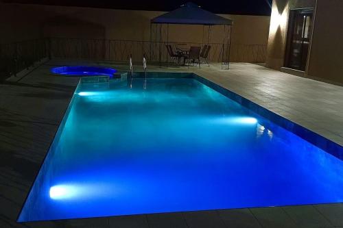 a swimming pool with blue lights in a house at Villa moderne avec grande piscine sans vis-à-vis Berkane Saïdia in Berkawe
