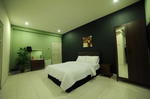 a bedroom with a large bed and a green wall at The Osborne Apartments in Ipoh