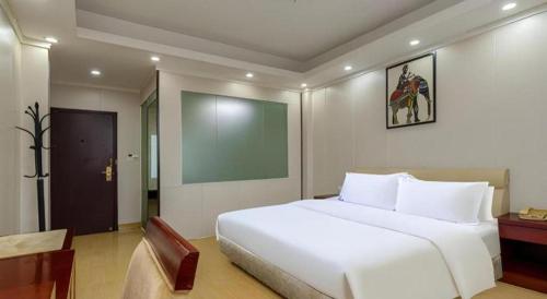 a bedroom with a large white bed in a room at Jian Guo Grand Hotel in Vientiane