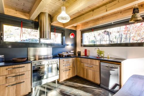 une cuisine avec des armoires en bois et des appareils en acier inoxydable dans l'établissement Chalet lux et Design Chamonix, à Servoz